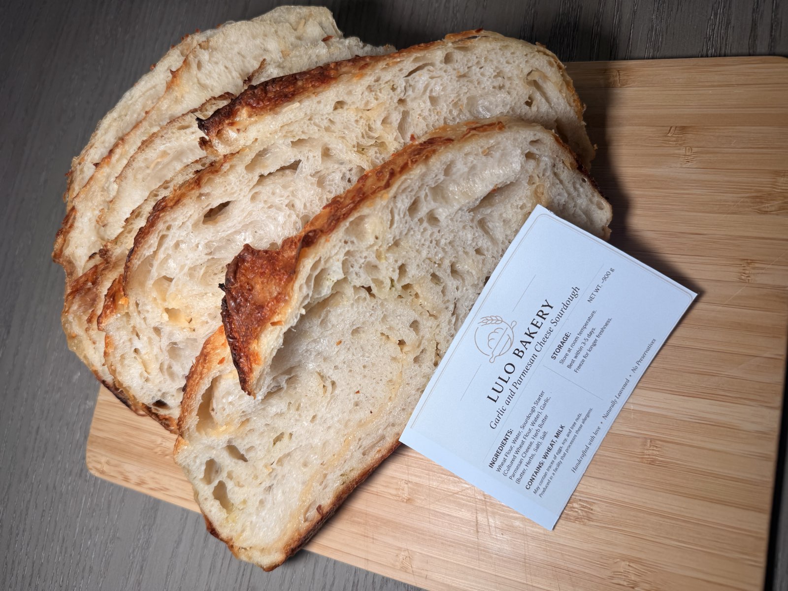 Garlic and Parmesan cheese sourdough sliced to show the open, cheesy crumb
